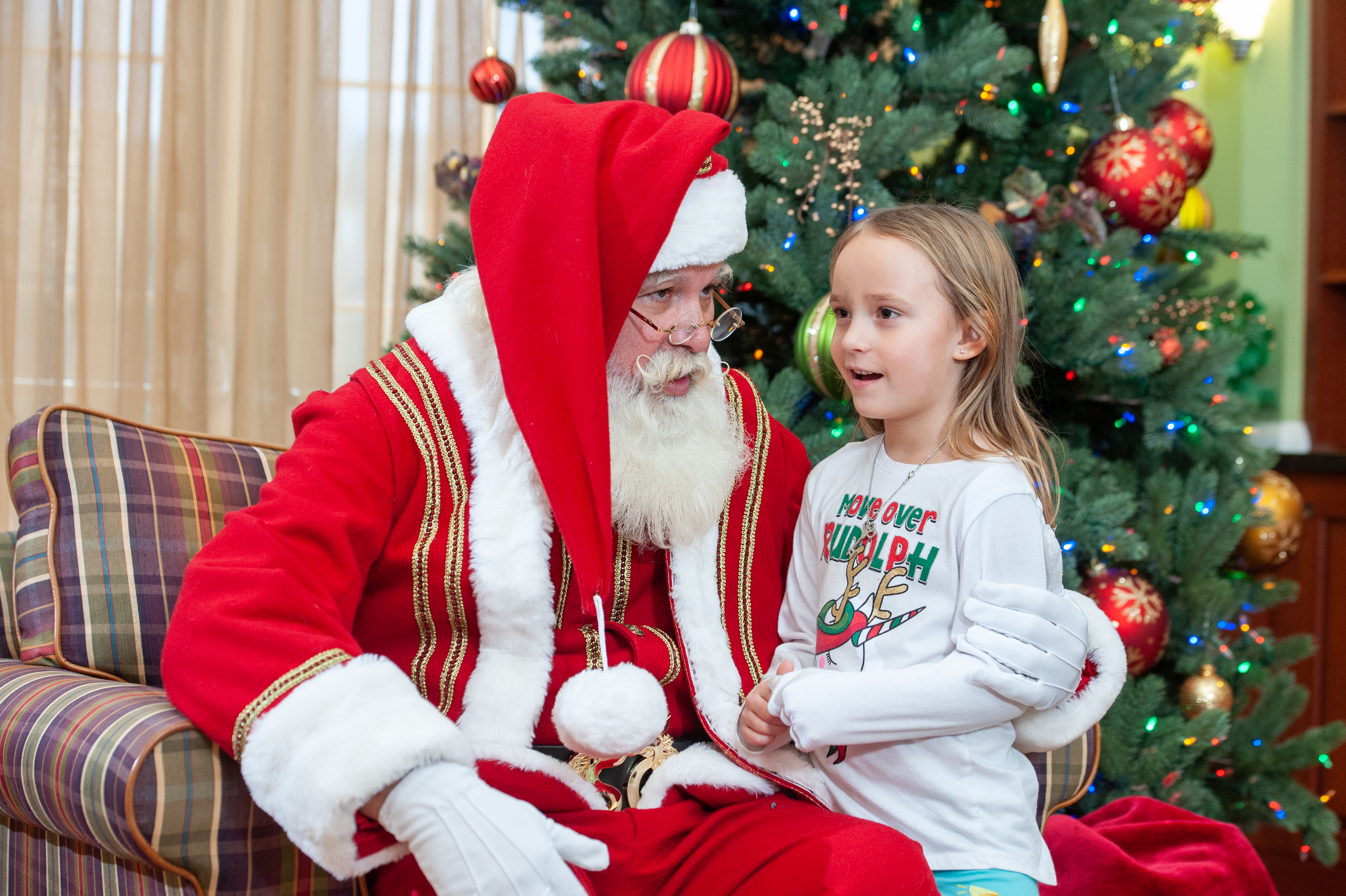 Santa listens as one of our precious residents relays that she has been a good girl and deserving of lots of presents under the tree! thumbnail